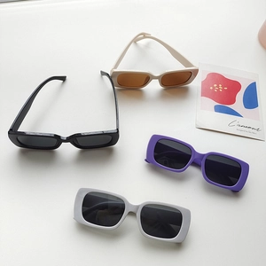 Flat lay of vintage square children's sunglasses in black, cream, purple, and grey colors