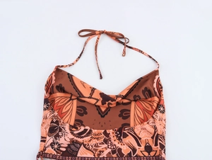 Detailed close-up of brown and orange paisley print satin halter top with silky texture
