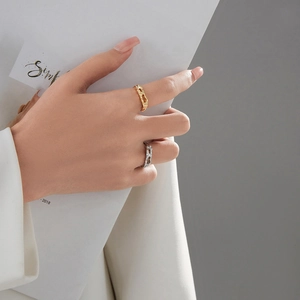 Detail of adjustable open rings featuring unique molten lava texture in gold and silver