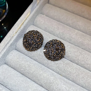 Vue macro de boucles d'oreilles clous en argent avec cristaux gris dans leur écrin