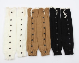 Detail of knitted leg warmers with lace trim and buttons in white, brown, and black