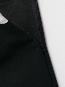 Detailed close-up of high-quality invisible zipper on black blazer and skort set fabric