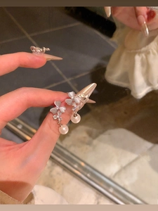 Detail of silver floral earring with light blue opal petals and white hanging pearl