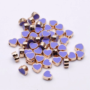 Macro detail of lavender heart enamel beads with gold plating for DIY jewelry