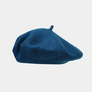 Close-up of deep teal wool beret featuring classic dome shape and soft fuzzy texture