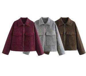 Détails d'une veste en laine à revers bordeaux, grise et marron avec grandes poches