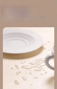 Waterproof cream leather table mat with woven texture showing water beads on surface
