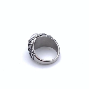 Macro detail of gothic bat demon eye ring with intricate floral carvings and white stone