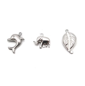 Macro detail of silver stainless steel charms in dolphin, elephant, and leaf shapes