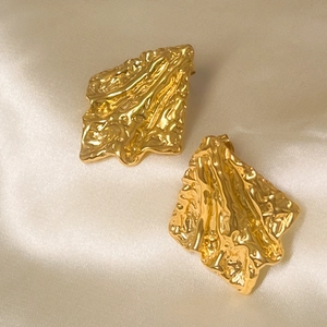 Detail of 18K gold plated stainless steel stud earrings with irregular wrinkled texture