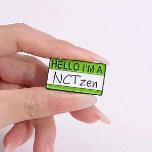 Green and white rectangular NCTzen enamel badge pin shown in a hand-held close-up view