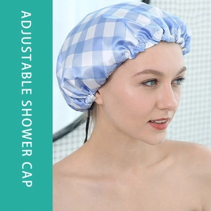 Adjustable waterproof shower cap with blue gingham pattern and satin lining worn by model