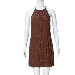 Detailed view of brown halter dress featuring tiered ruffles and pleated fabric texture