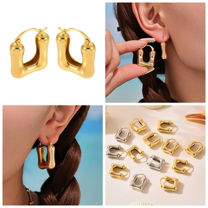 Detailed view of U-shaped chunky earrings in polished gold and silver finishes