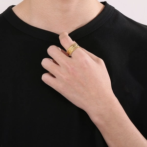 Detail view of a gold leaf feather ring for men, showcasing texture on a male hand