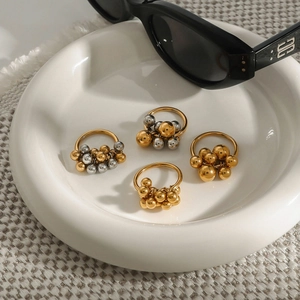 Mostra macro di anelli a sfere d'oro e d'argento su un piatto di ceramica bianca