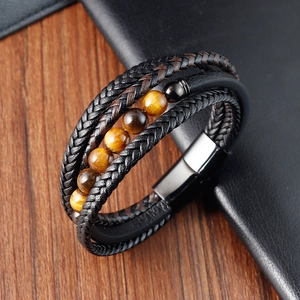 Détail d'un bracelet multicouche en cuir tressé avec pierres œil de tigre et fermoir