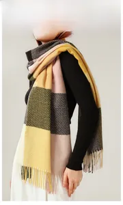 Detail of soft plaid cashmere-feel scarf featuring yellow and pink tassels and thick weave