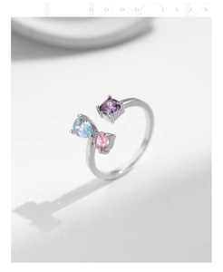 Macro shot of silver adjustable open ring with colorful square, teardrop and round gems