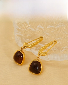 Detail of 18K gold-plated vintage spiral earrings with brown translucent stone
