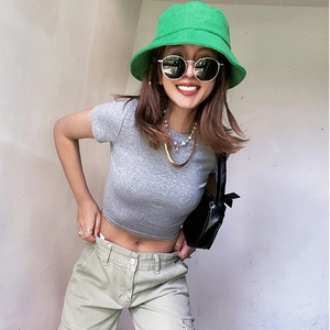 Street style view of a fashion green terry bucket hat paired with a grey cropped top