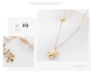 Detailed view of polished gold star pendant with double star design on link chain necklace