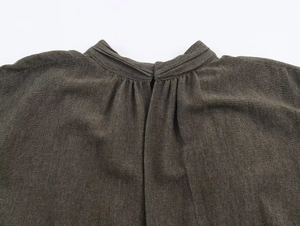 Detailed view of the gathered neckline and linen texture on a dark taupe mini dress