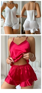 Detailed view of satin pajama set with ruffle trim and glossy silk texture in red and white