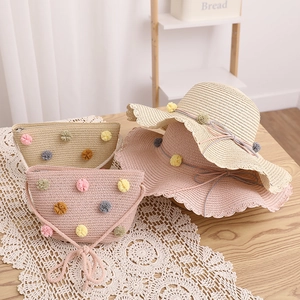 Detailed straw hat and bag set with colorful pom-poms and delicate lace trim