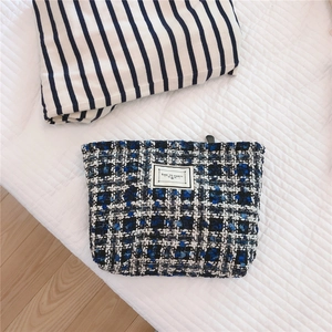 Detail of tweed makeup bag in blue and black pattern with Time To Party label