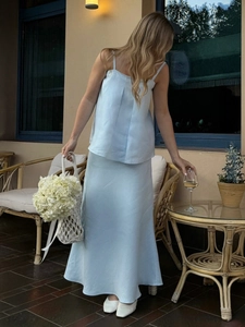 Detail of light blue linen two-piece set featuring camisole top and A-line midi skirt