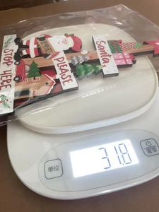 Weight measurement of wooden Christmas ornament with Santa Claus and tree motifs