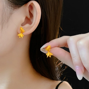 Gros plan détaillé des boucles d'oreilles carpe koï dorées avec écailles fines et queue fluide
