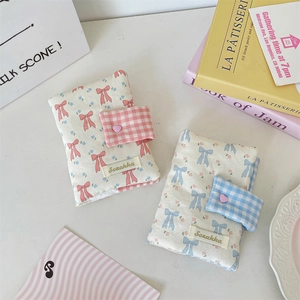 Close-up of handmade fabric book cover featuring cute bows and floral patterns