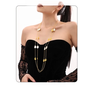 Detail of layered gold stainless steel necklace with square enamel pendants on model