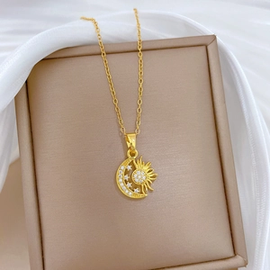 Elegant gold celestial necklace featuring a crescent moon and sun pendant with crystals