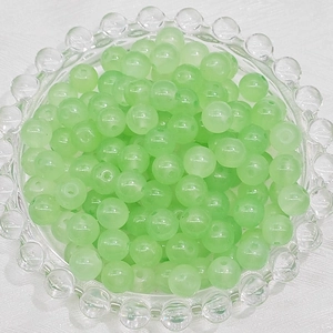 Detailed view of light green translucent 6mm glass beads for handmade jewelry DIY projects