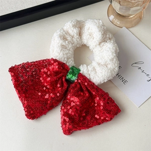 Detail of Christmas scrunchie with white faux fur and red sequined bow accessory