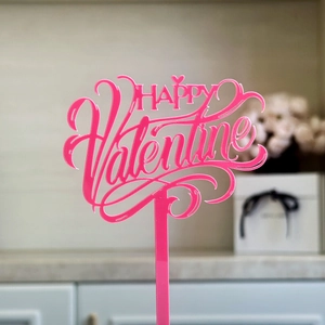 Detailed close-up of a pink acrylic cake topper with HAPPY Valentine hollow engraving