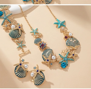 Détail d'ensemble de bijoux de plage avec étoiles de mer en émail et perles