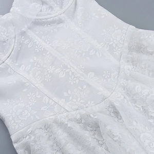 Gros plan sur la dentelle florale blanche et détails de couture d'une robe d'été