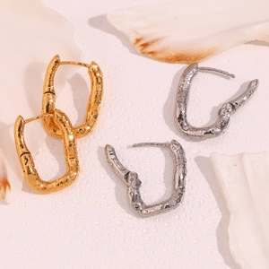 Irregular hammered U-shaped earrings in gold and silver finish with metallic texture