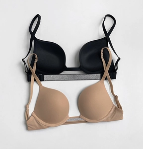 Detail of push-up bras with rhinestone straps in black and beige smooth fabric