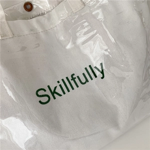 Minimalist transparent PVC and canvas tote bag in green print with metallic snap button