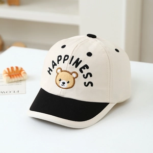 Macro shot of embroidered bear and happiness text on a beige cotton baseball cap