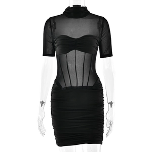 Detail of black mini dress featuring a sheer mesh bodice with structured corset design