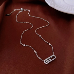 Macro view of silver tone oval sliding pendant with sparkling zircons on satin fabric