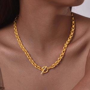 Detail of a minimalist gold OT buckle necklace with round link chain on model