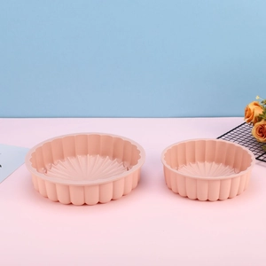 Detailed view of pink silicone cake molds with fluted edges in two versatile sizes
