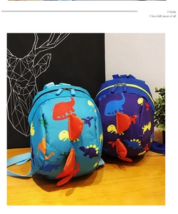 Detail shot of blue cartoon dinosaur backpacks for toddlers with 3D soft spikes on a desk
